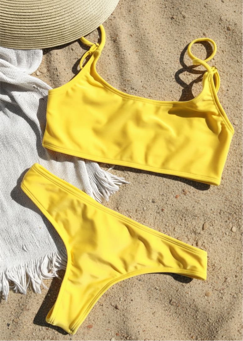 Bikini de top estilo deportivo y braguita tanga en color amarillo - vista del bikini sobre la arena
